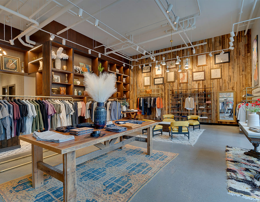 Interior of a stylish clothing store with wooden furniture and wooden walls.