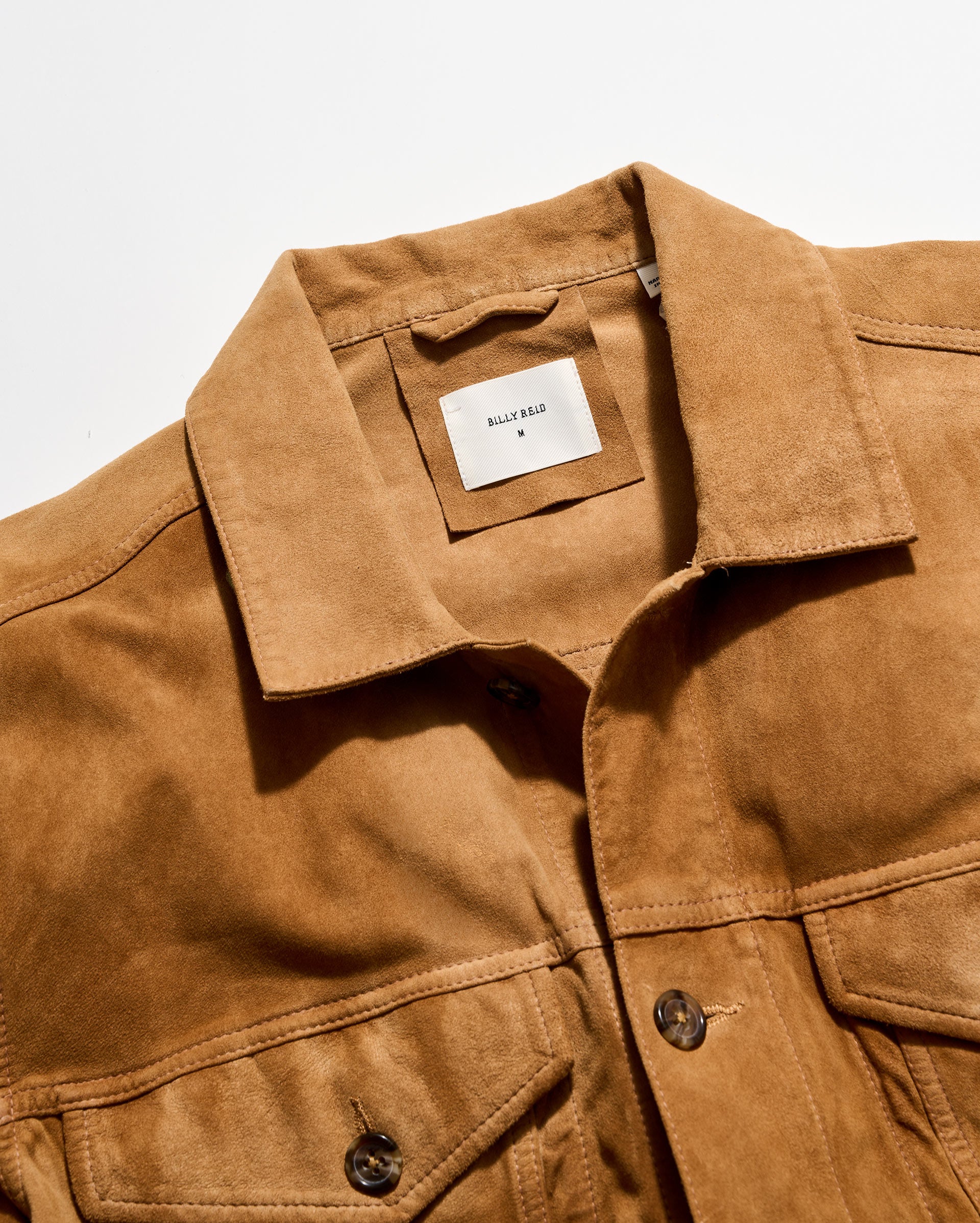 Brown jacket with a brand label on a light gray background