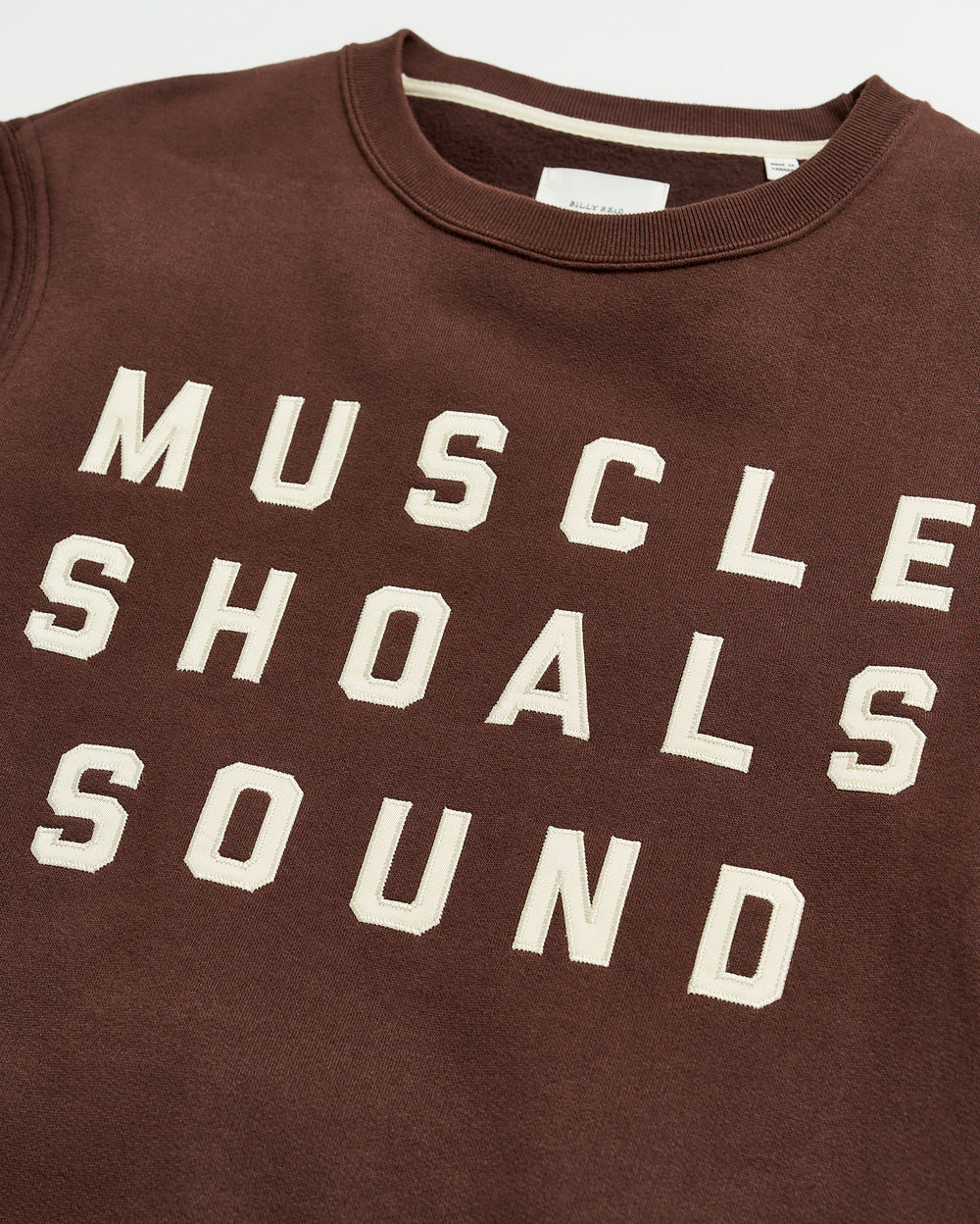 A brown sweatshirt with bold, white block lettering that reads MUSCLE SHOALS SOUND across the front.