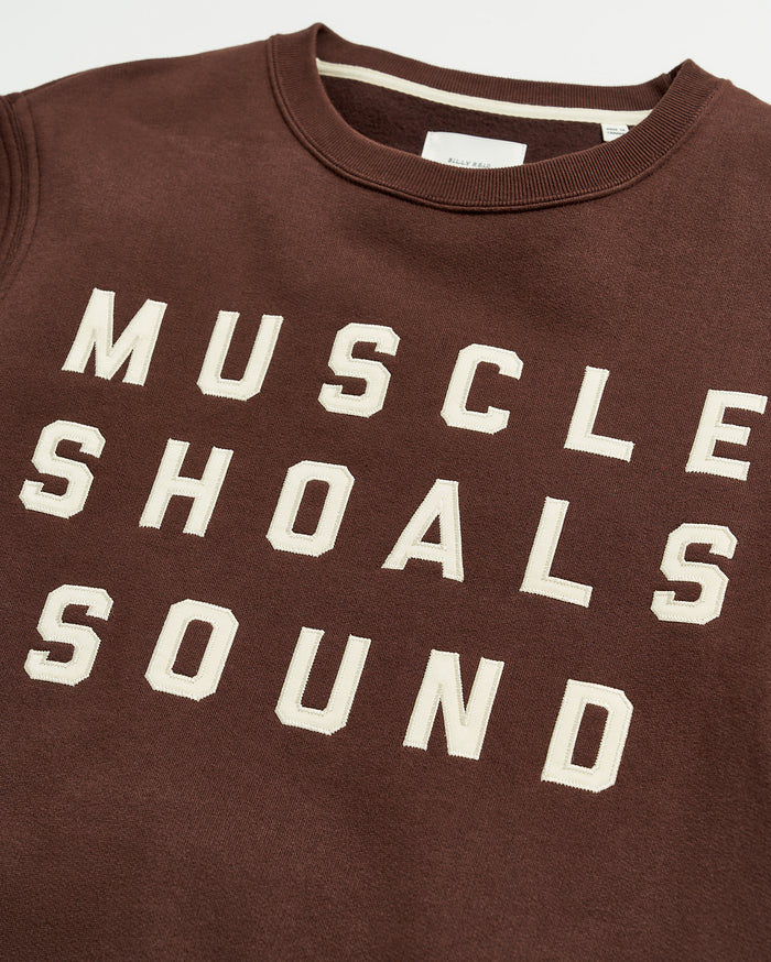 A brown sweatshirt with bold, white block lettering that reads MUSCLE SHOALS SOUND across the front.