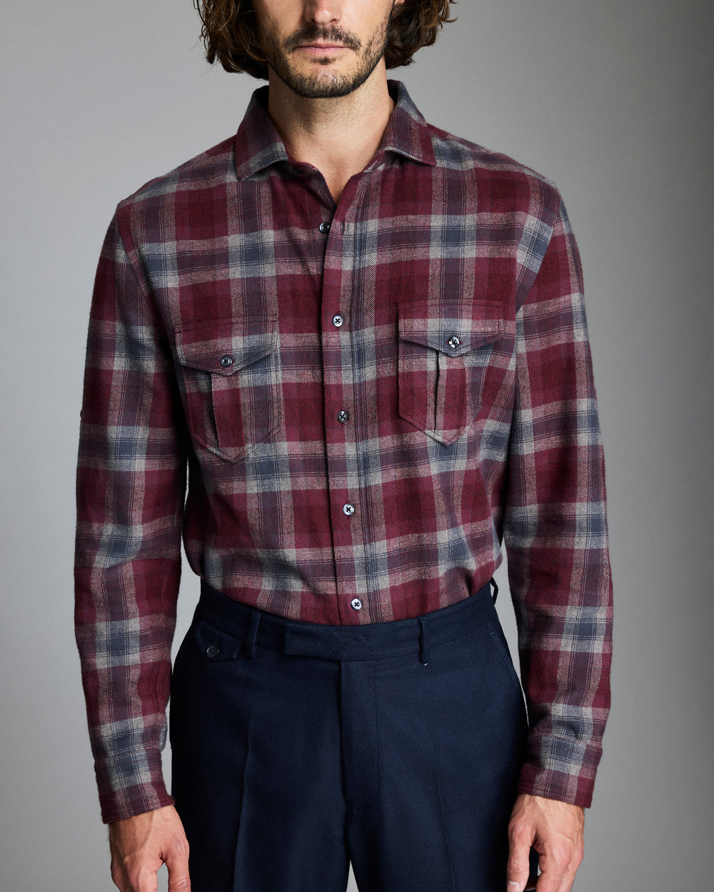 Man wearing a plaid shirt with a gray background