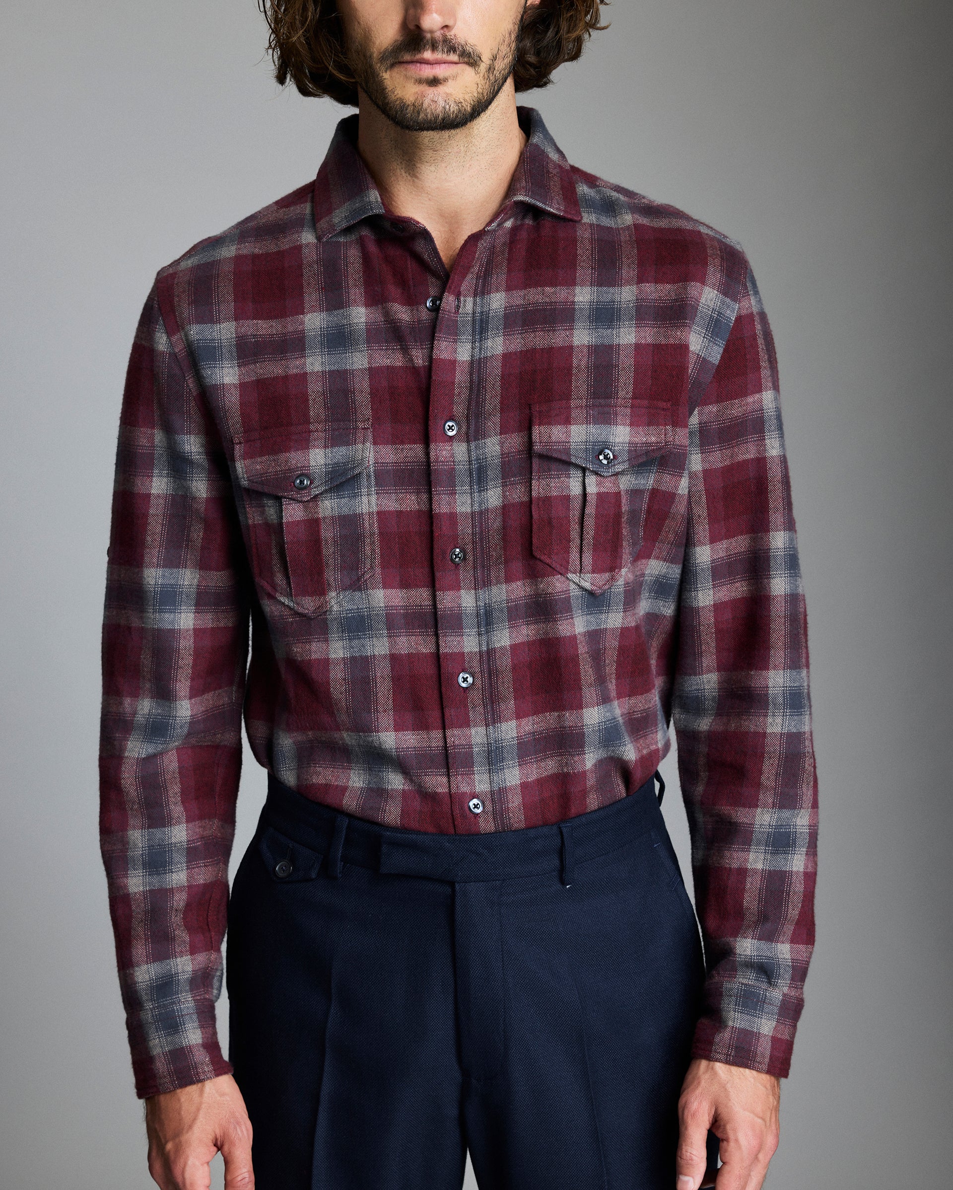 Man wearing a plaid shirt with a gray background