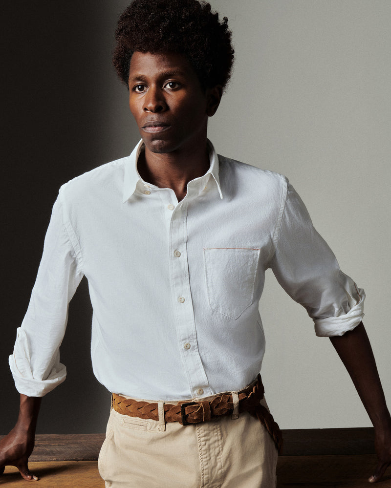 Man wearing a white shirt and beige pants against a neutral background Alternate