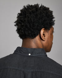 Person wearing a black shirt with a gray background