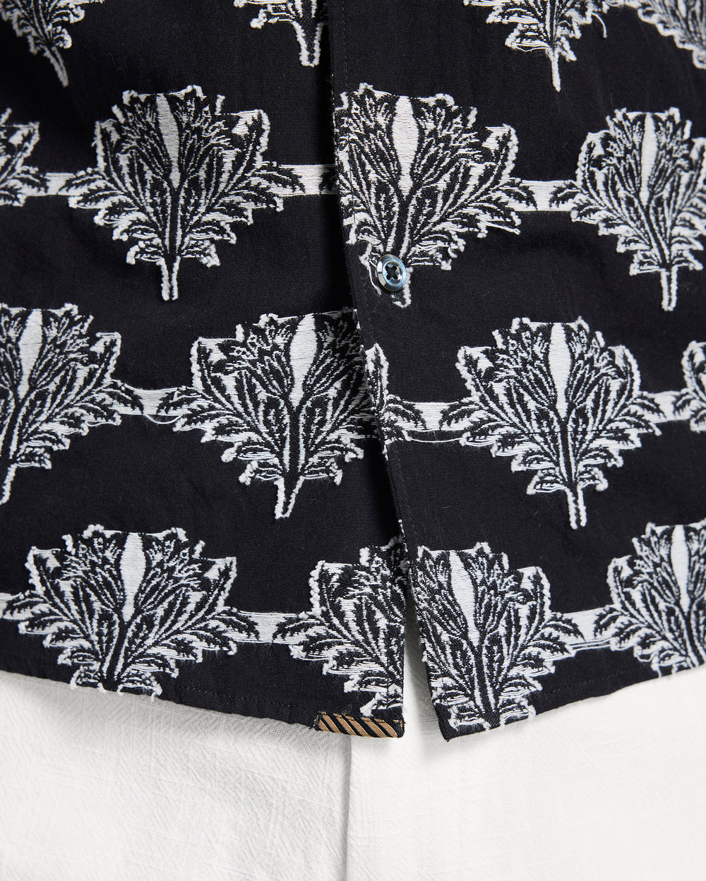 Close-up of black fabric with white leaf pattern on a white background