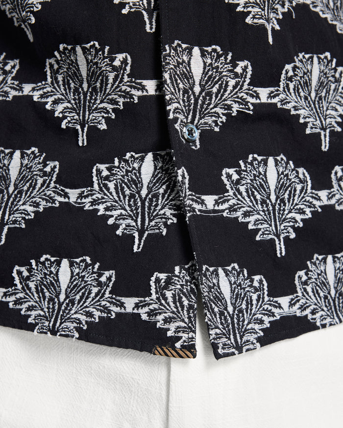 Close-up of black fabric with white leaf pattern on a white background
