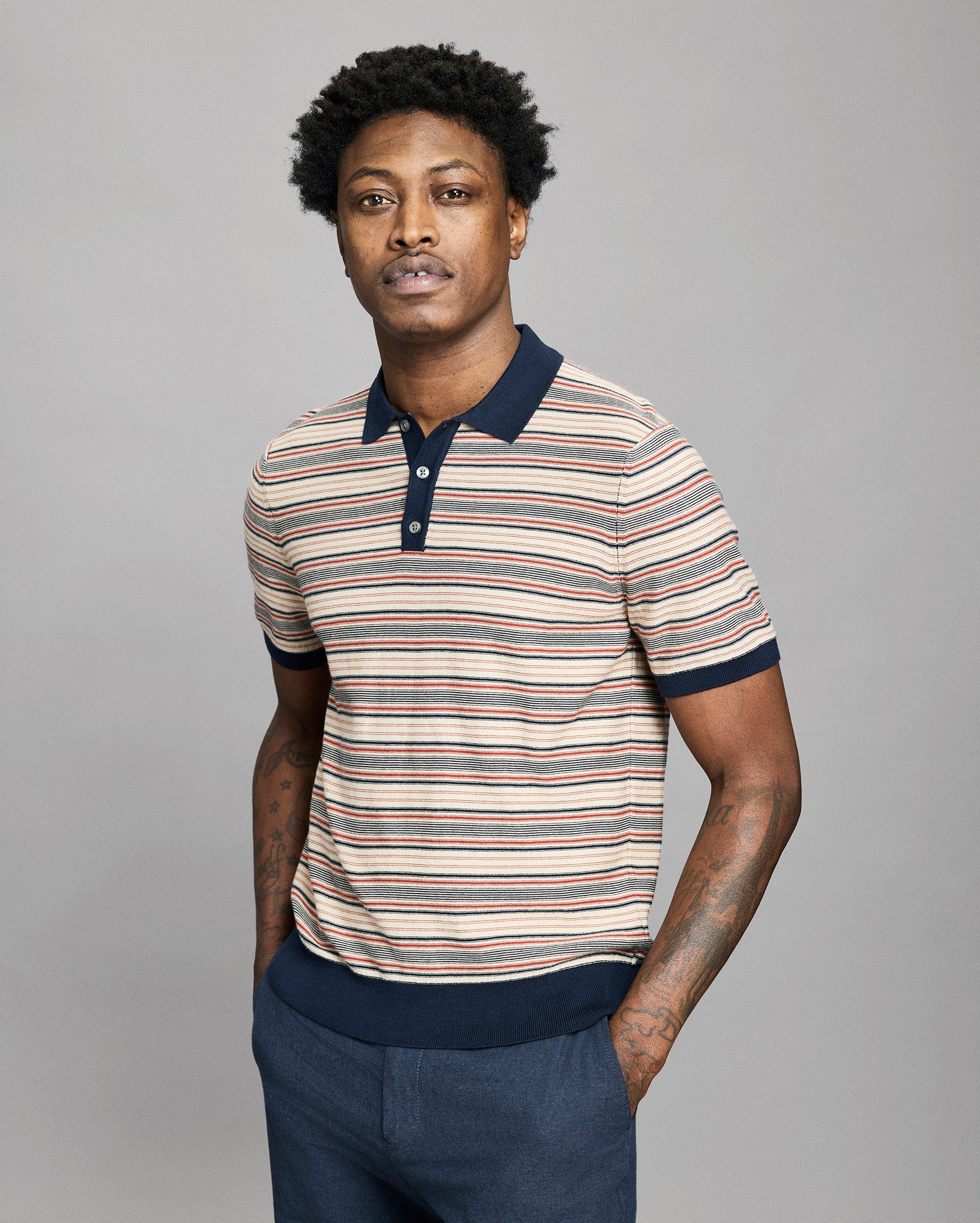 Model wears a striped polo on a light gray background