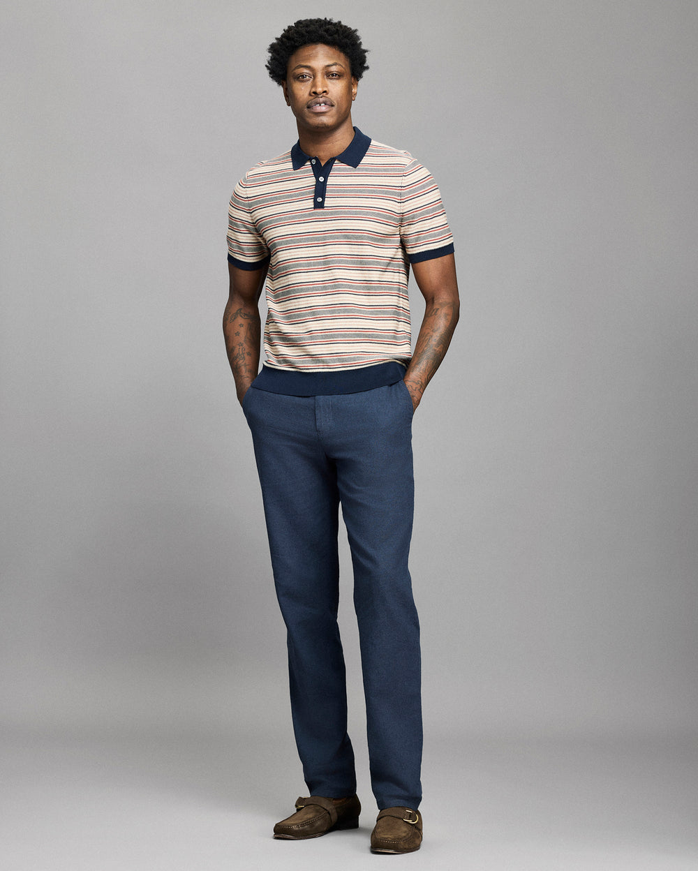 Model wears a striped polo on a light gray background