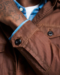 Close-up of a brown jacket with blue lining and visible buttons.