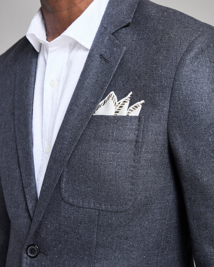 Gray suit jacket with a white shirt and patterned pocket square.