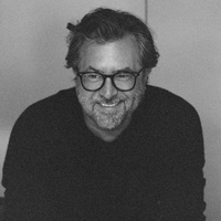 Billy Reid smiles at someone off camera.