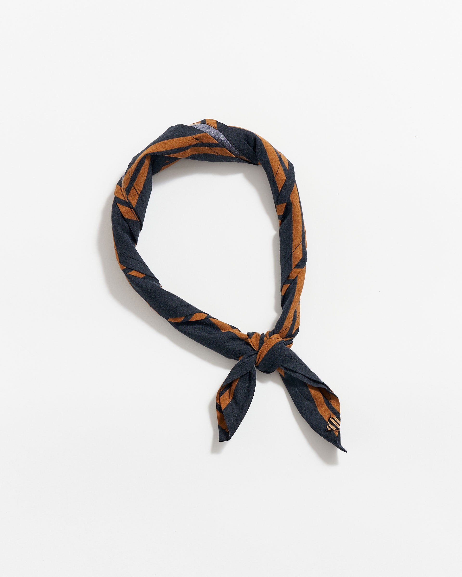 A navy blue scarf with brown geometric patterns, tied in a loose knot, displayed on a plain white background.