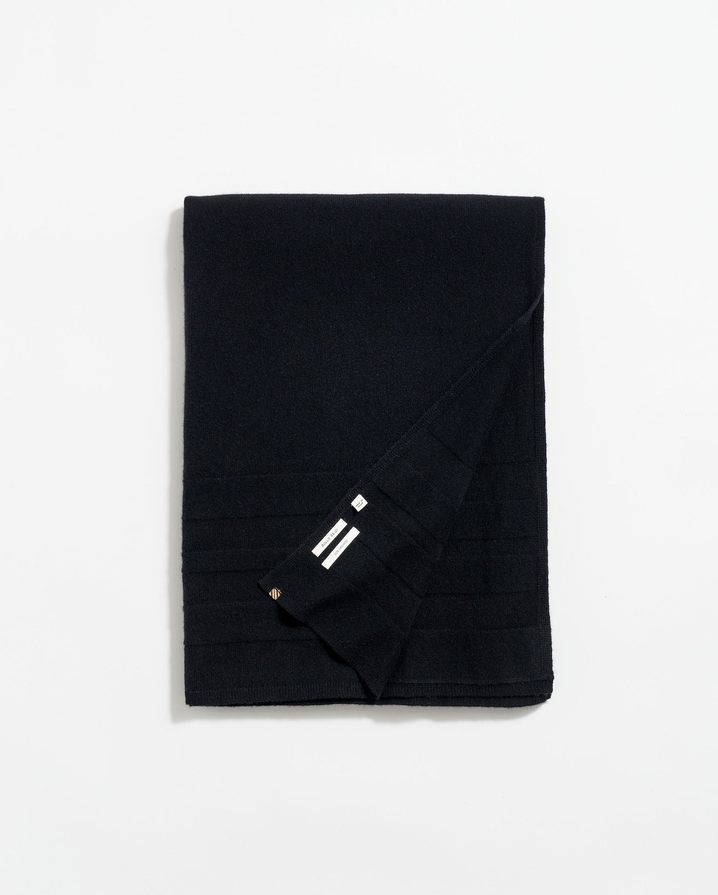 A neatly folded black scarf with subtle horizontal lines and a small section showing three white stripes near the corner, displayed on a plain white background.