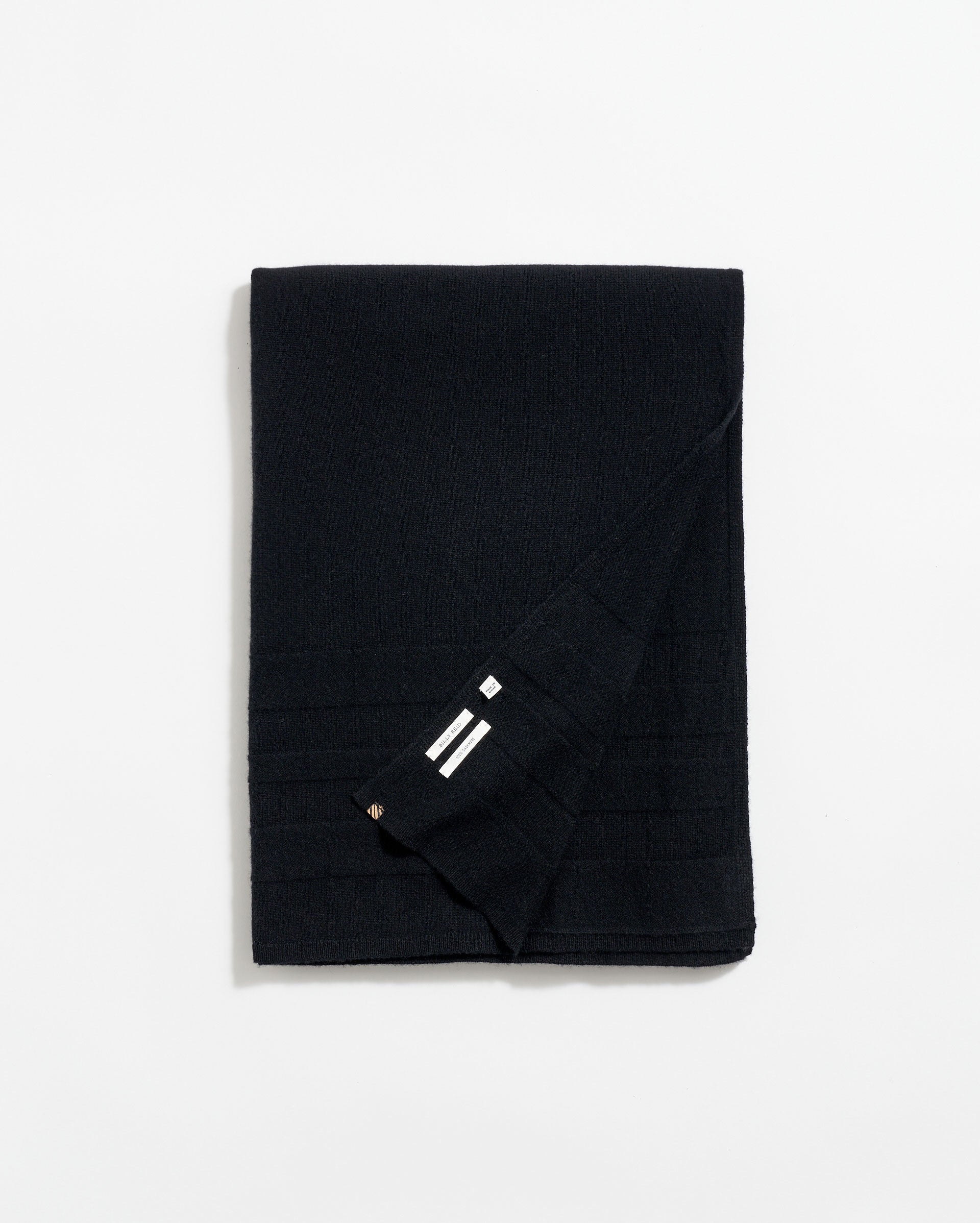 A neatly folded black scarf with subtle horizontal lines and a small section showing three white stripes near the corner, displayed on a plain white background.