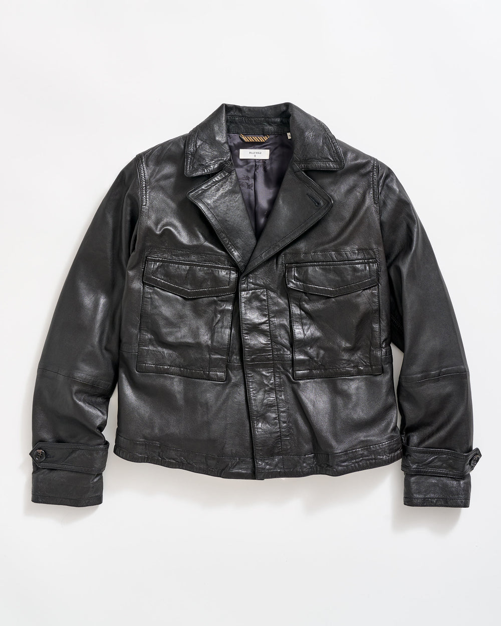 A black leather jacket with large front pockets, buttoned cuffs, and a notched collar, laid flat on a white background.