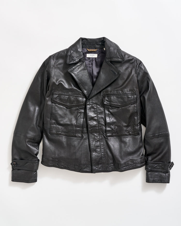 A black leather jacket with large front pockets, buttoned cuffs, and a notched collar, laid flat on a white background.