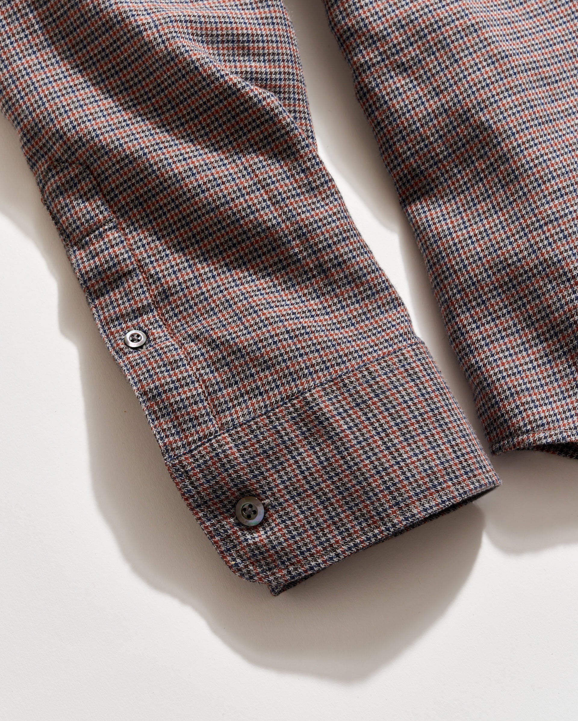Plaid shirt with a button on a light background