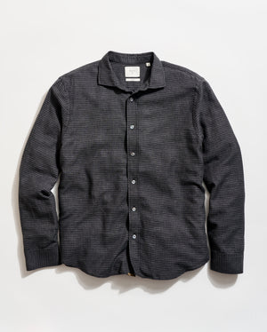 Black checkered shirt on a light beige background