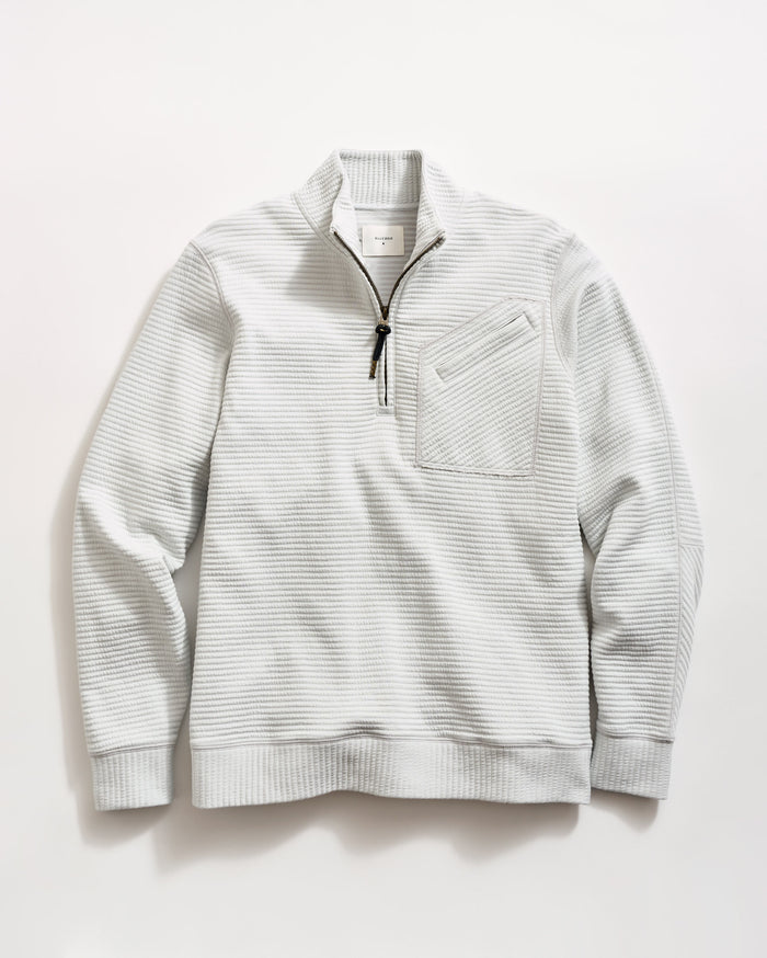 Light gray, long-sleeve pullover sweater with a quarter-zip front, black zipper pull, ribbed cuffs and hem, and a textured waffle pattern. A small chest pocket with a diagonal opening is on the left side.