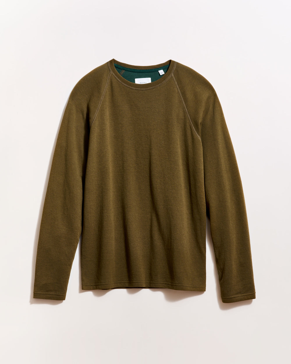 An olive green long-sleeve crewneck shirt is laid flat on a light background, with a green inner collar visible.