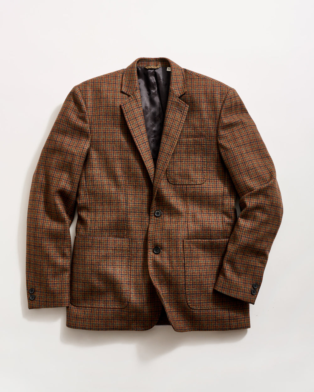 A brown plaid blazer with a notched lapel, two buttons, and three front pockets, laid flat on a white background.