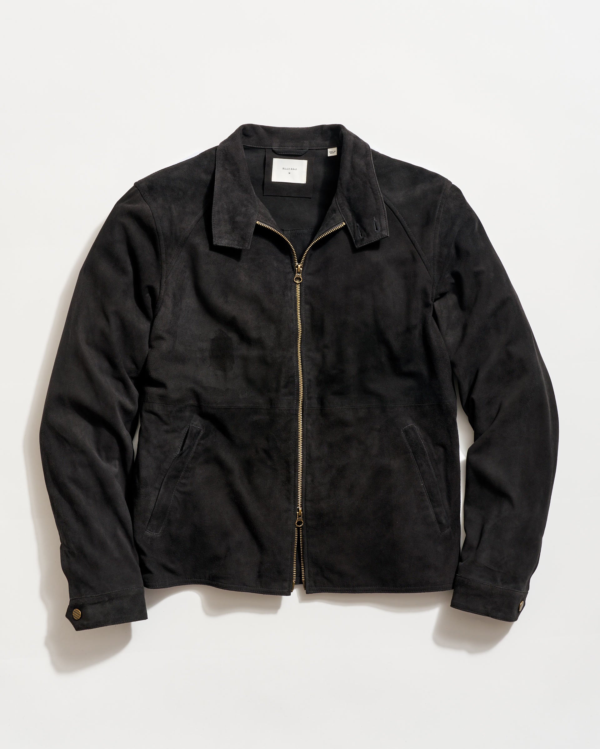 Black jacket with a gold zipper on a light gray background