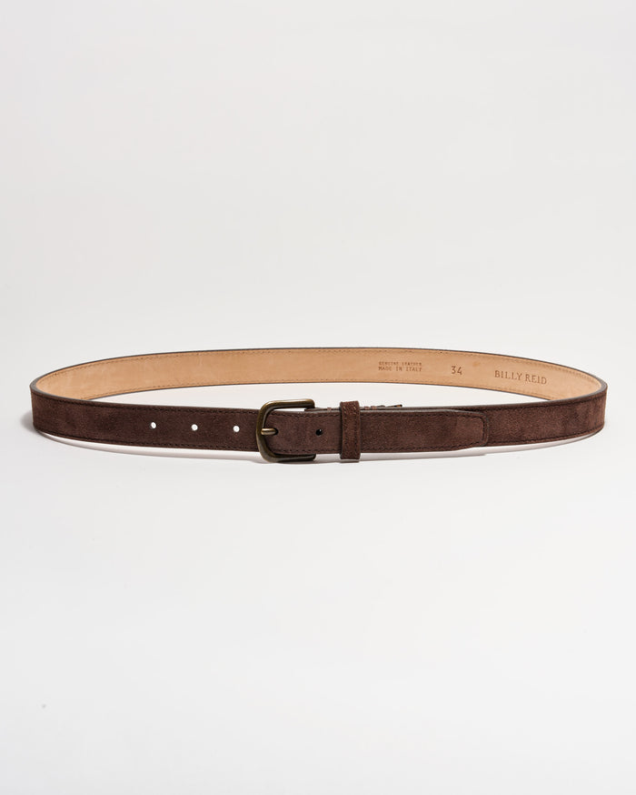 A brown suede leather belt with a brass buckle, laid flat in a circular shape on a white background. The interior of the belt is tan, and several adjustment holes are visible.