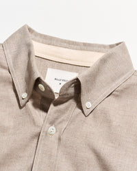 Close-up of a light beige button-down shirt collar with white buttons and a visible Billy Reid neck label.