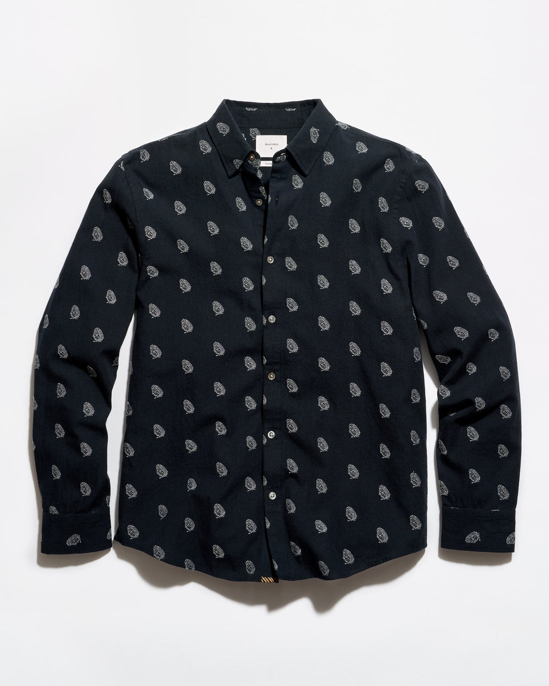 A long-sleeve button-up shirt in black with a repeating small white paisley pattern, laid flat against a white background.