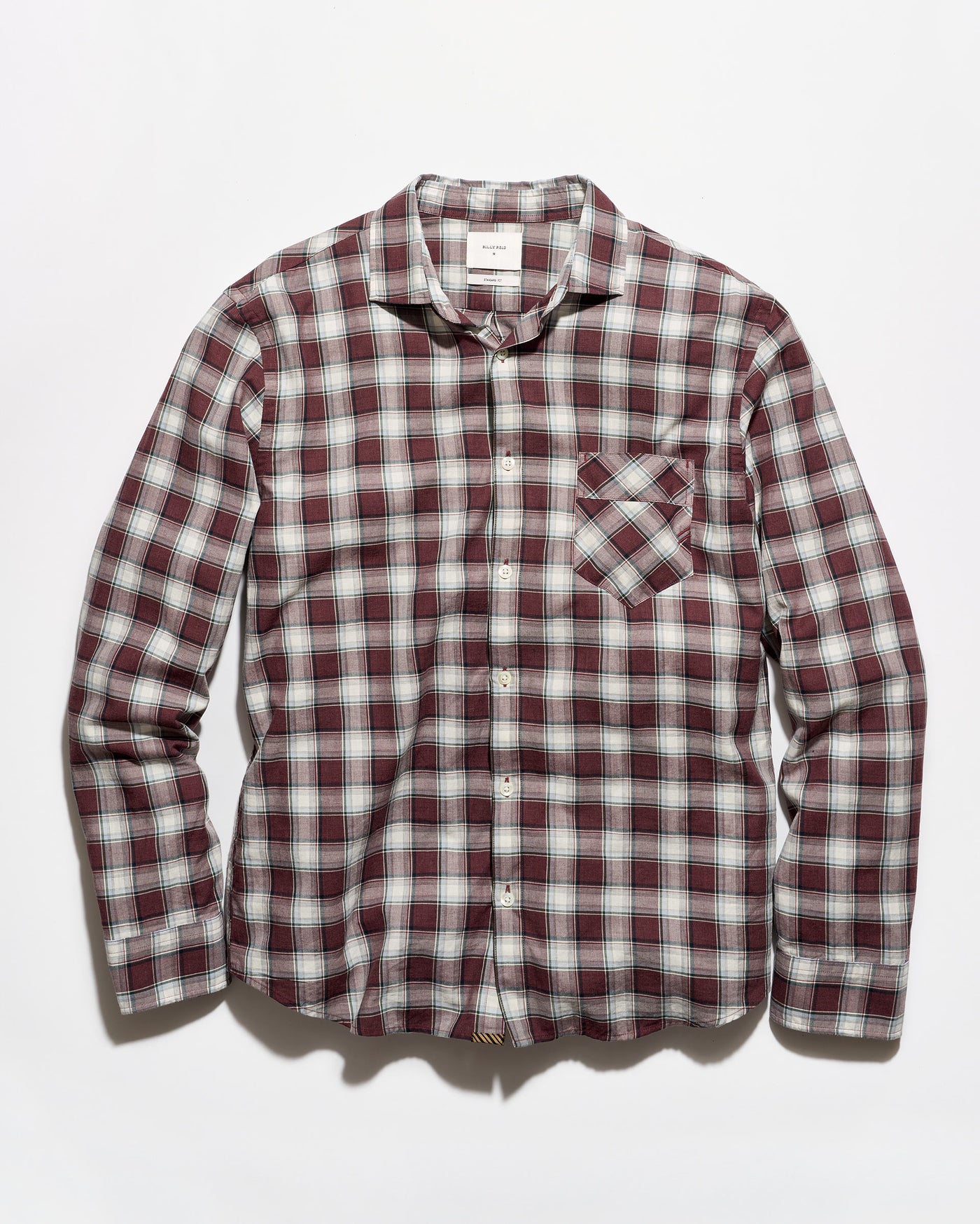 A long-sleeve button-up plaid shirt in a burgundy, white, and gray checkered pattern, featuring a single chest pocket, laid flat against a light gray background.