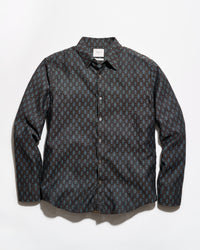 A long-sleeve button-up shirt with a dark charcoal gray and black base, featuring a repeating small geometric pattern in muted blue and brown tones, laid flat against a light gray background.