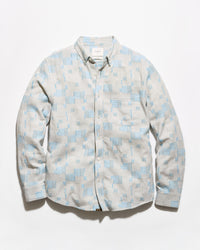 A long-sleeve button-up shirt with a light blue and off-white geometric pattern, laid flat against a white background.