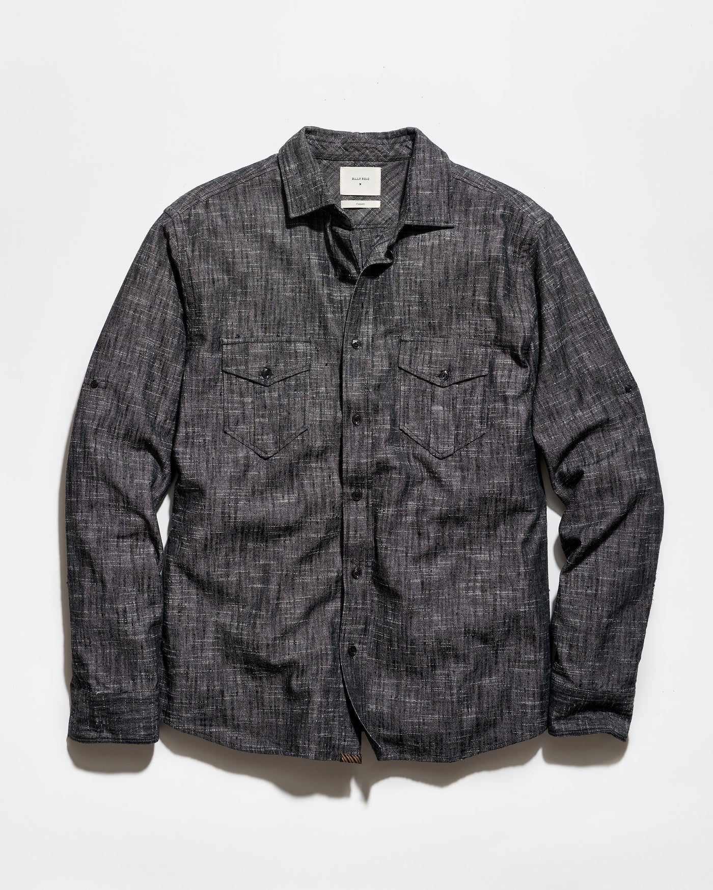 A dark gray textured long-sleeve button-up shirt with two chest flap pockets, laid flat against a white background.