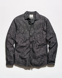 A dark gray textured long-sleeve button-up shirt with two chest flap pockets, laid flat against a white background.