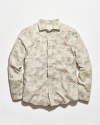 A long-sleeve button-up shirt with a beige base and an all-over delicate floral and branch print in muted pink and gray-green, laid flat against a light background.