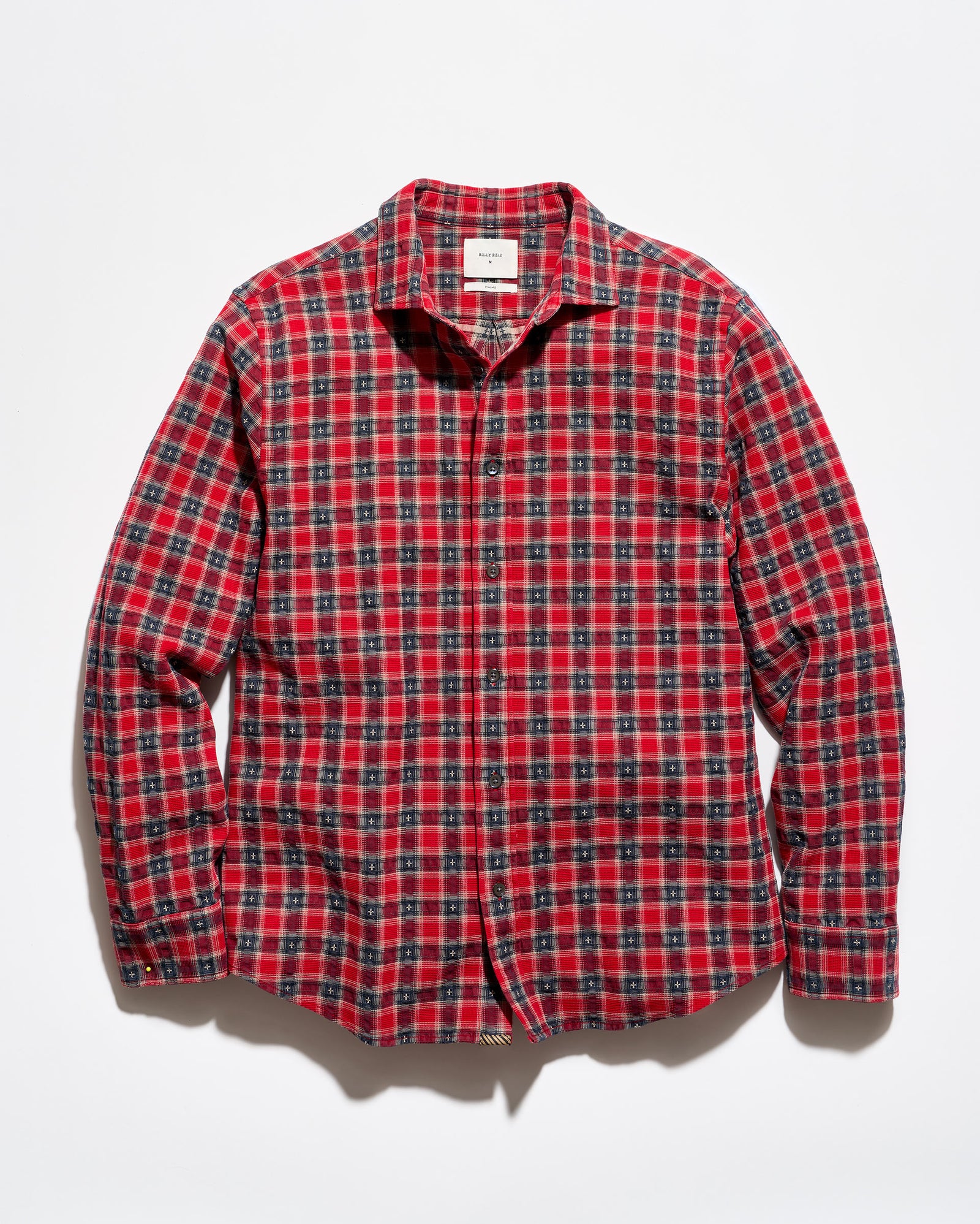A red and black plaid long-sleeve button-up shirt laid flat against a white background.