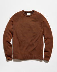 A brown crewneck knit sweater with raglan sleeves, laid flat against a clean white background.