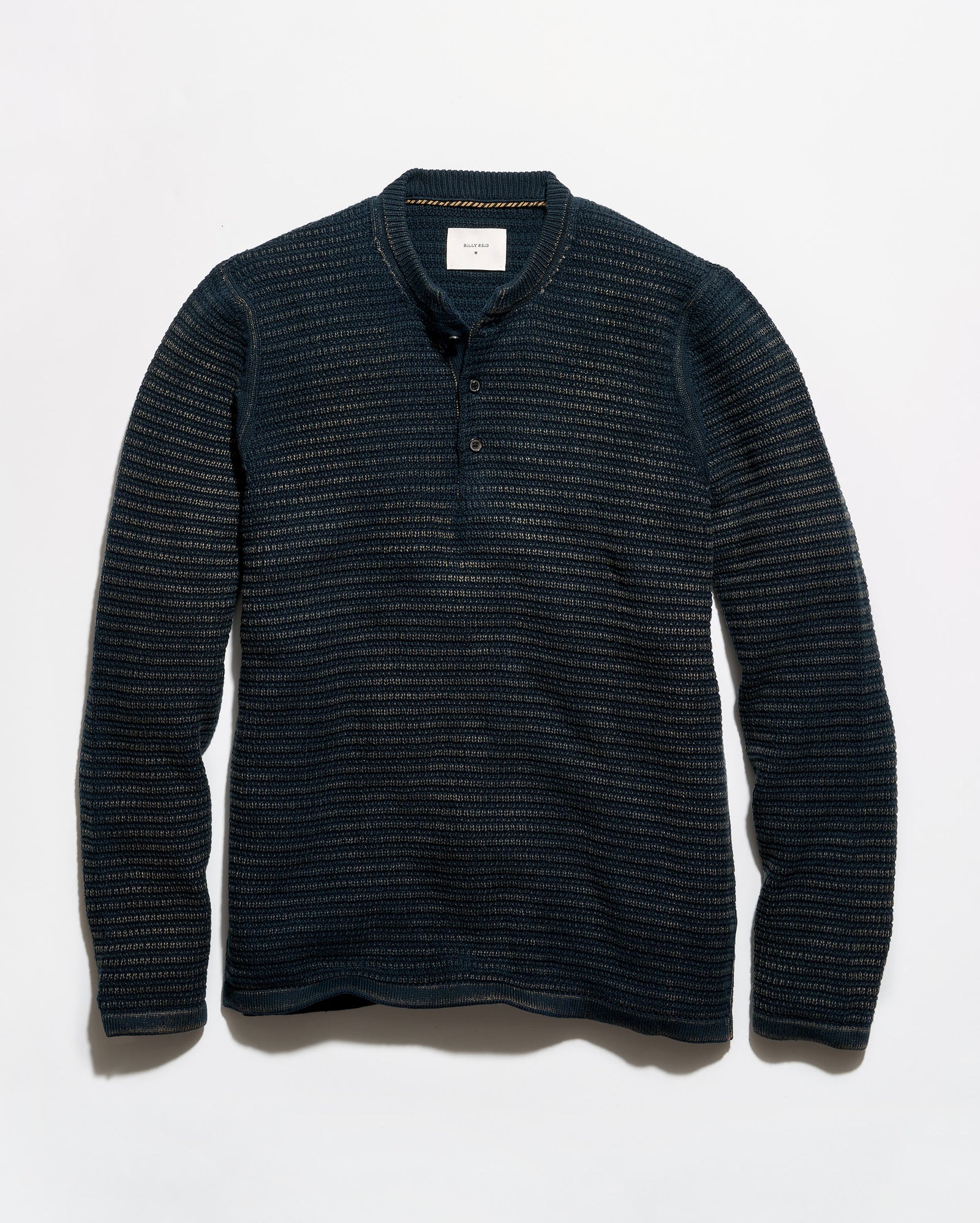 A dark navy blue long-sleeve henley shirt with a textured, fine horizontal stripe pattern, laid flat against a light gray background.