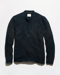 A dark navy blue long-sleeve henley shirt with a textured, fine horizontal stripe pattern, laid flat against a light gray background.
