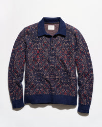 A long-sleeve knit polo-style sweater with an intricate geometric pattern in navy blue, burgundy red, and beige, featuring solid navy ribbed trim on the collar, cuffs, and hem.