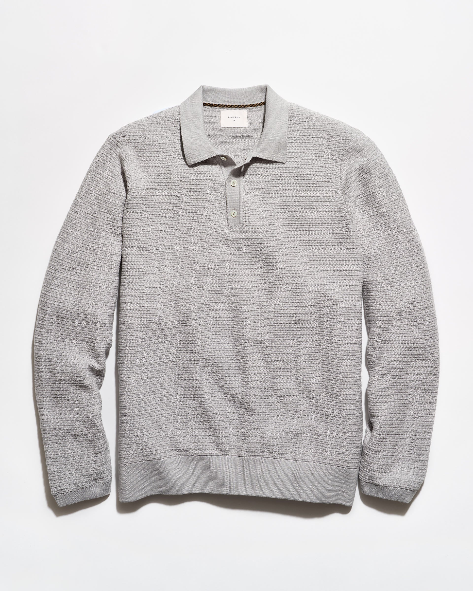 A light gray ribbed knit polo sweater with a collar and three-button placket, laid flat against a white background.