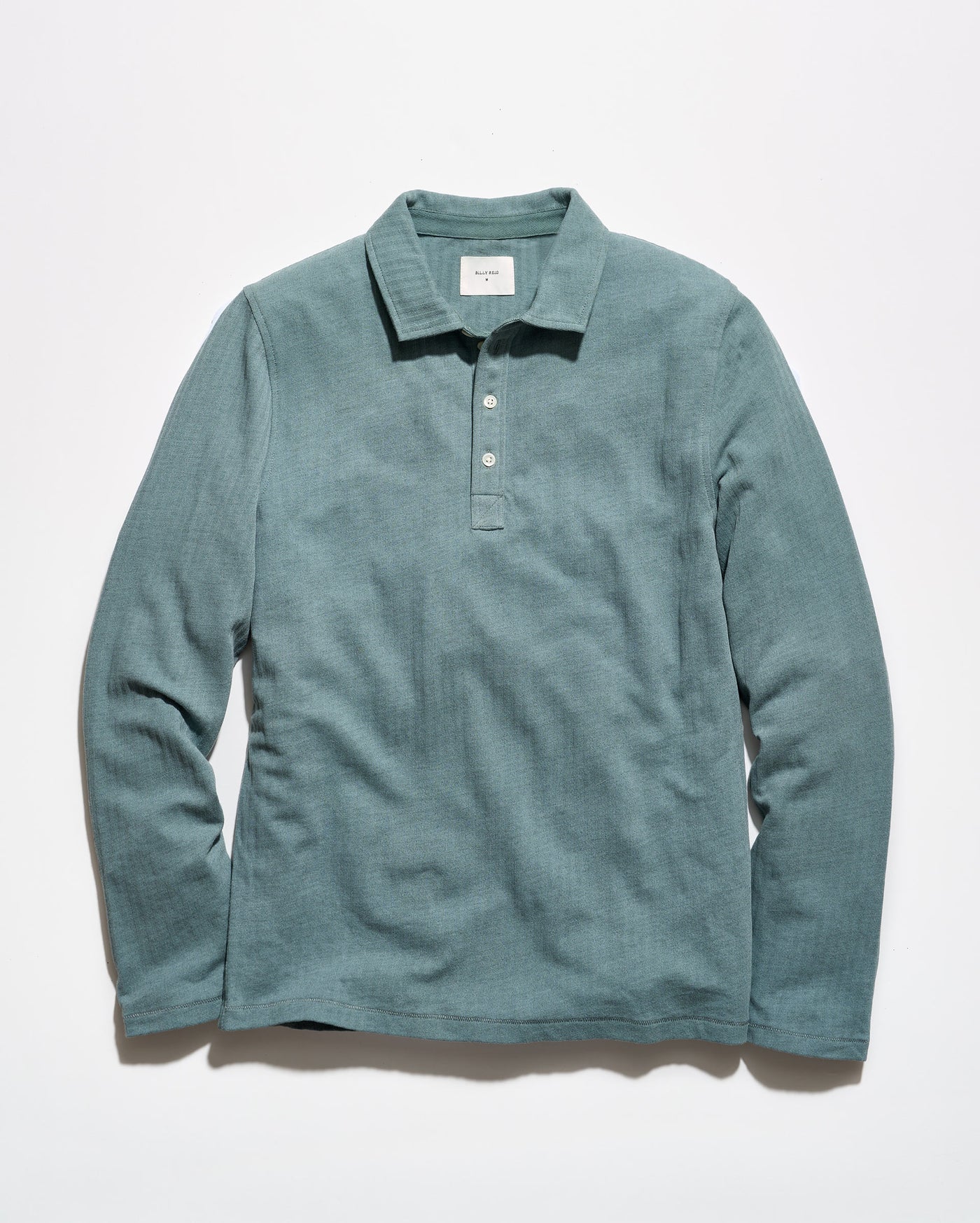A long-sleeve polo shirt in a muted teal-green color, laid flat against a clean white background.