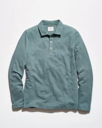 A long-sleeve polo shirt in a muted teal-green color, laid flat against a clean white background.