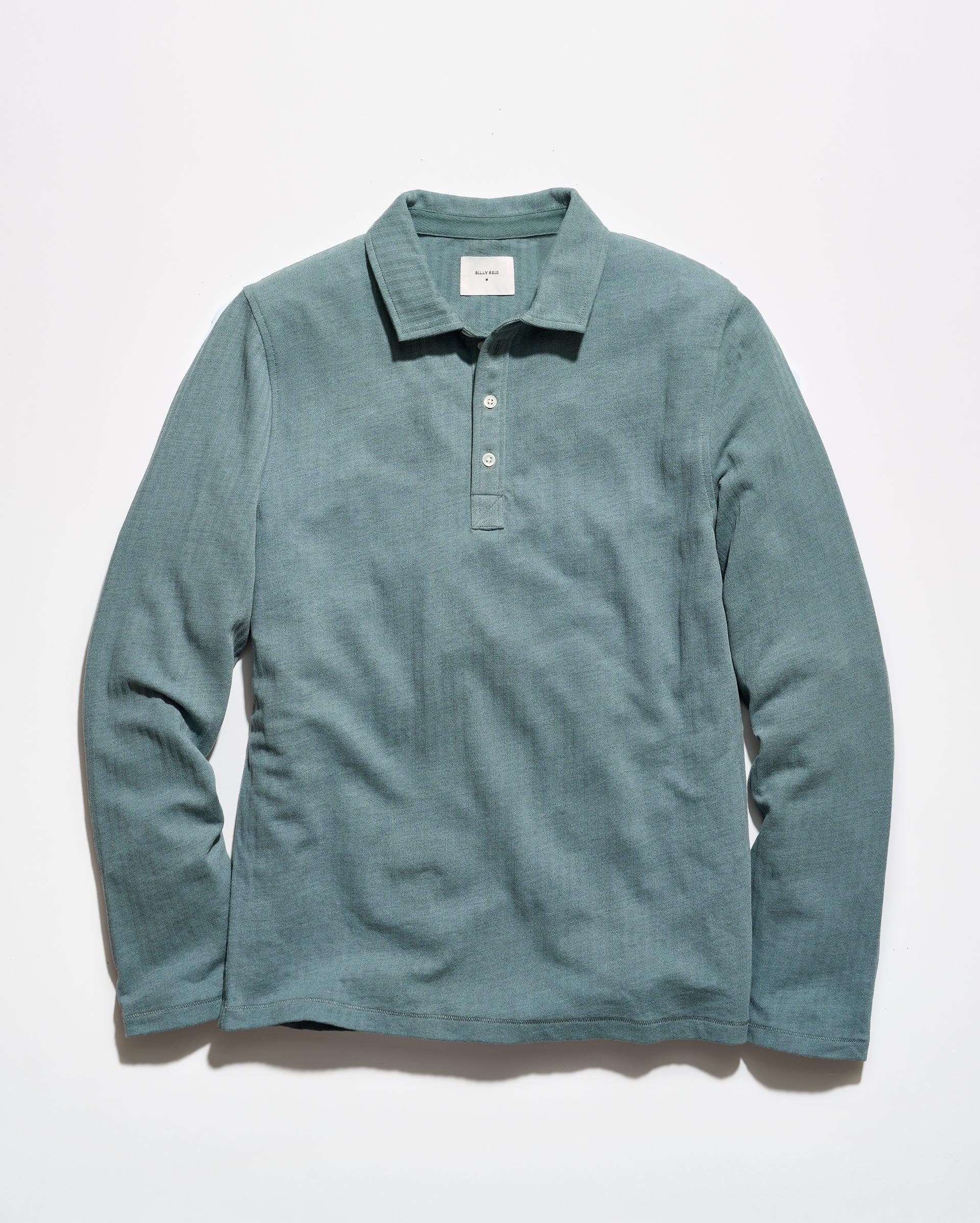 A long-sleeve polo shirt in a muted teal-green color, laid flat against a clean white background.