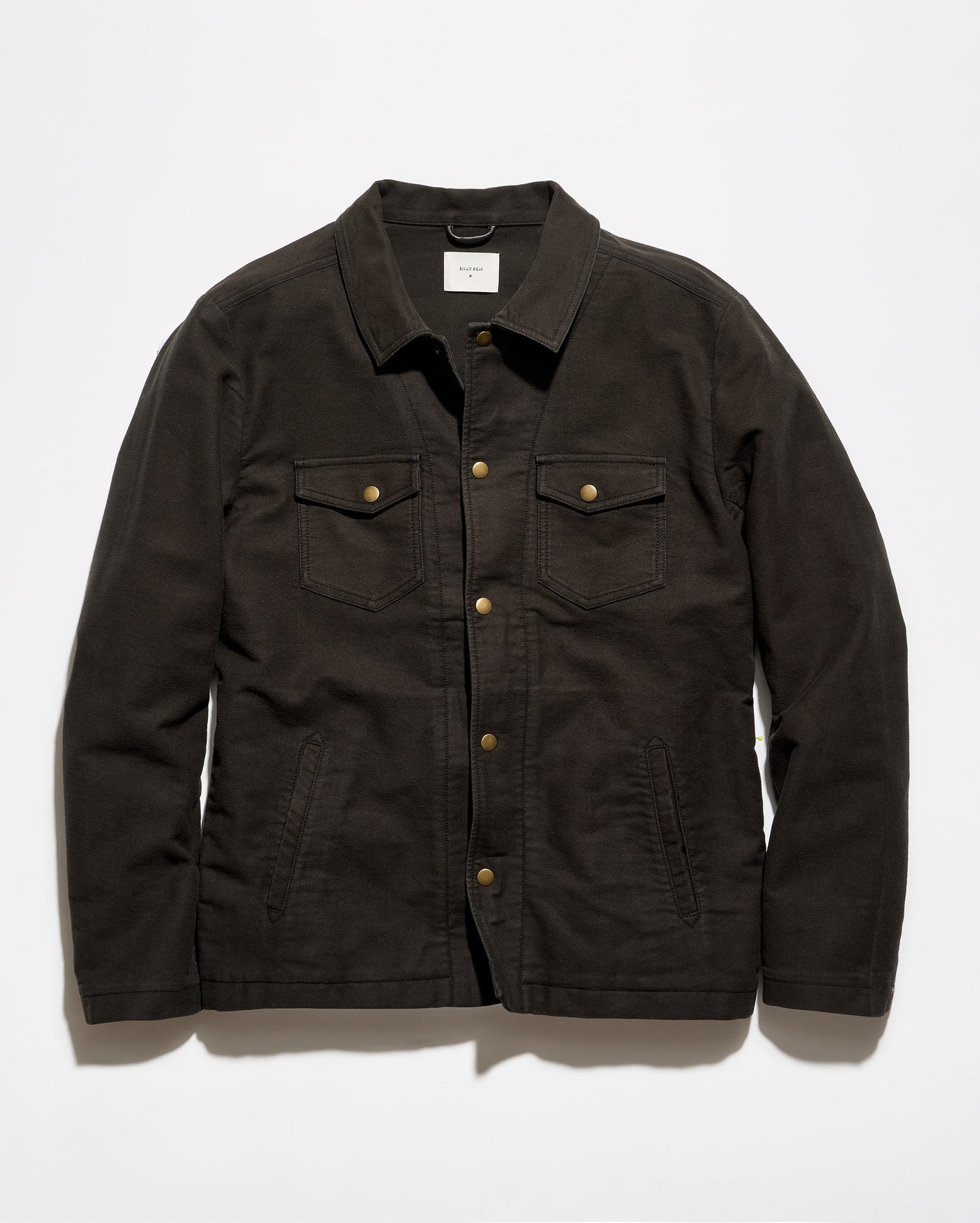 A dark brown canvas utility jacket with brass buttons, laid flat against a light gray background.
