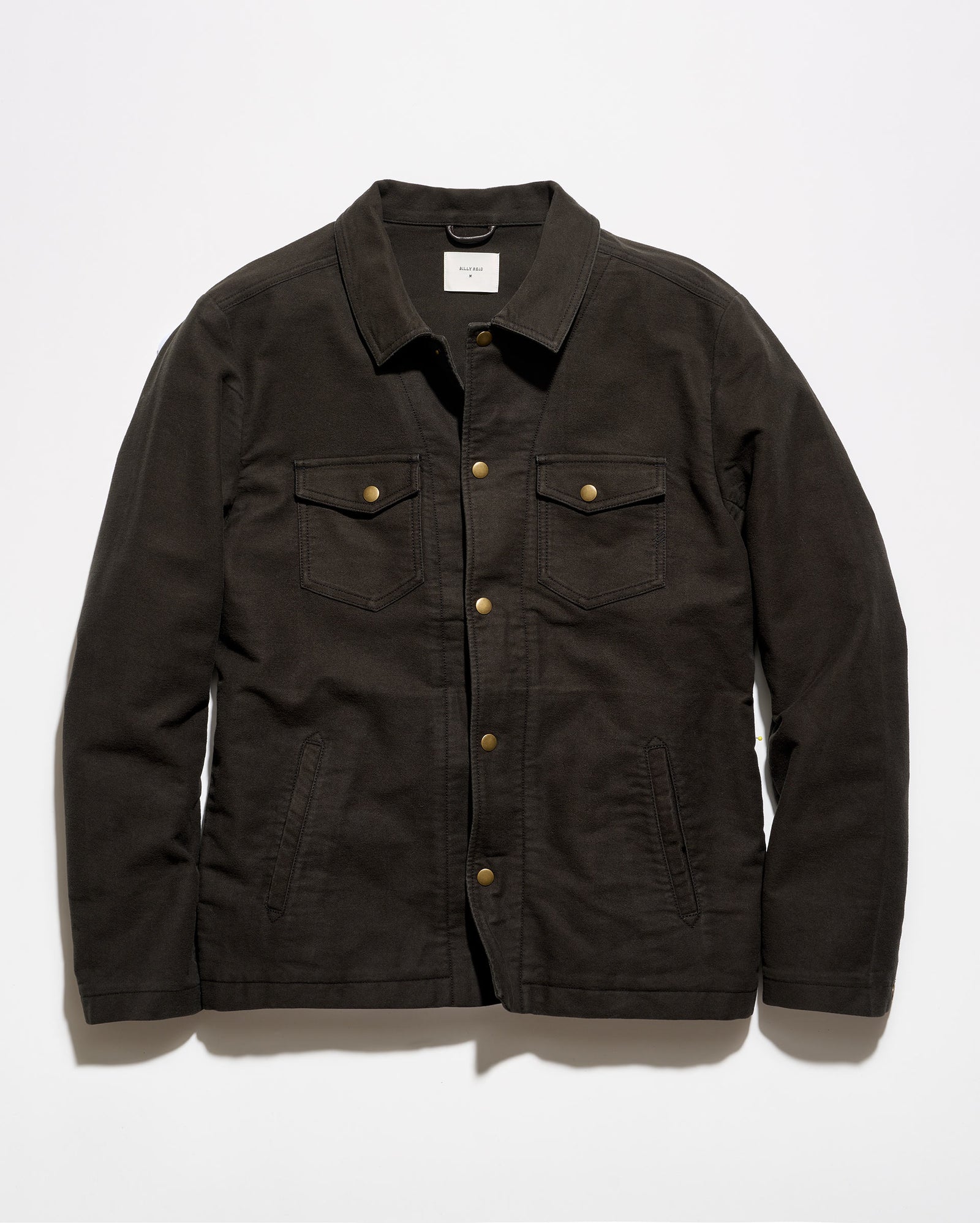 A dark brown canvas utility jacket with brass buttons, laid flat against a light gray background.