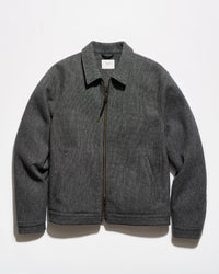 A dark gray zip-up jacket with a pointed collar and side pockets, laid flat against a white background.