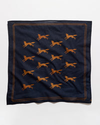 A square navy blue scarf featuring a repeating pattern of running foxes in a warm orange-brown color, framed by a thin orange-brown border line, shown against a plain white background.