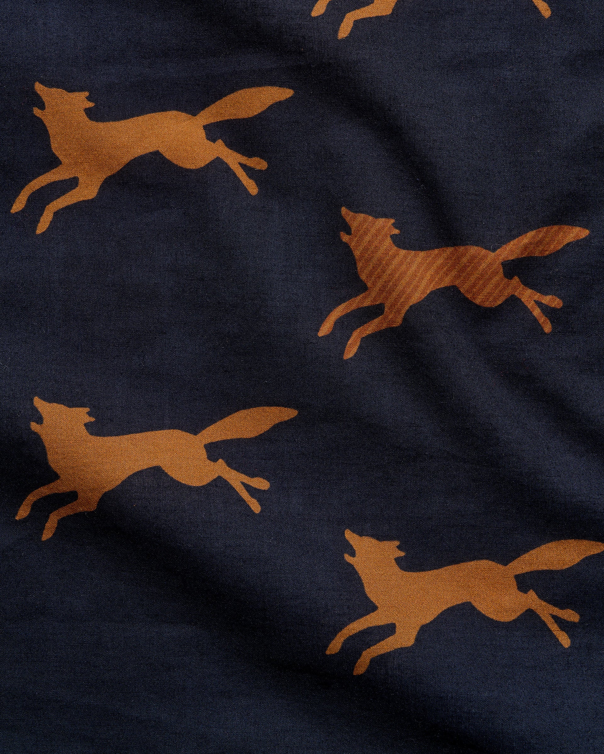 Close-up of a navy blue fabric with a repeating pattern of running foxes in a warm tan or camel color.