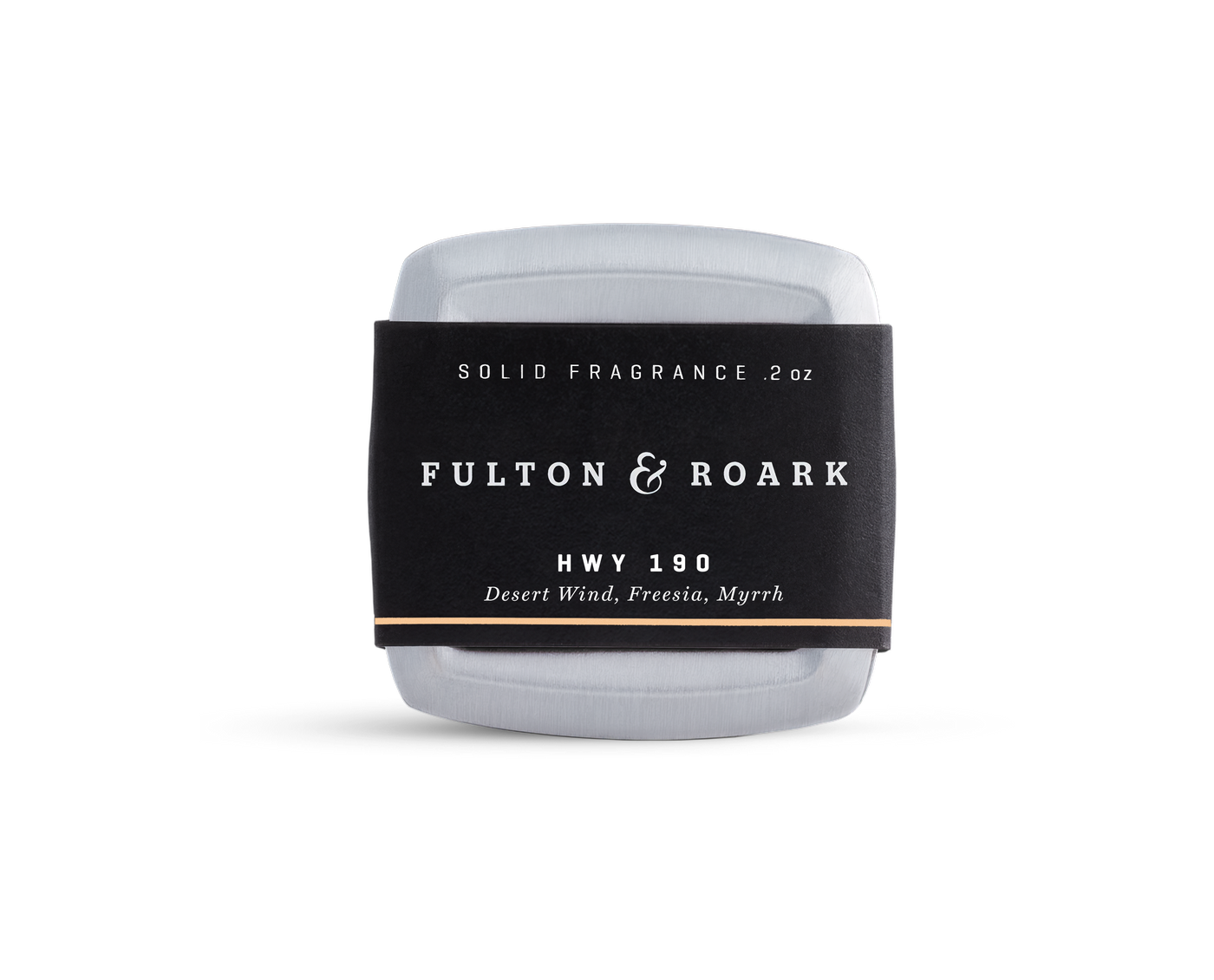 A rectangular metal tin of Fulton & Roark solid fragrance, HWY 190, with a black label featuring the scents Desert Wind, Freesia, and Myrrh. The tin is placed against a plain white background.